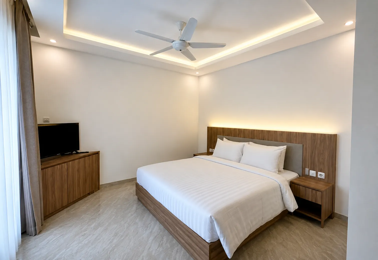 Two-Bedroom Villa bedroom with wooden furniture, ceiling fan and soft cove lighting.